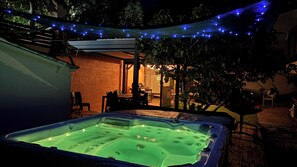 An outdoor hot tub area with a brick wall and a covered seating area. - Cozy house with a private hot tub, 80 m from the ocean, 200 m from downtown, parking available (La Tranche-sur-Mer)