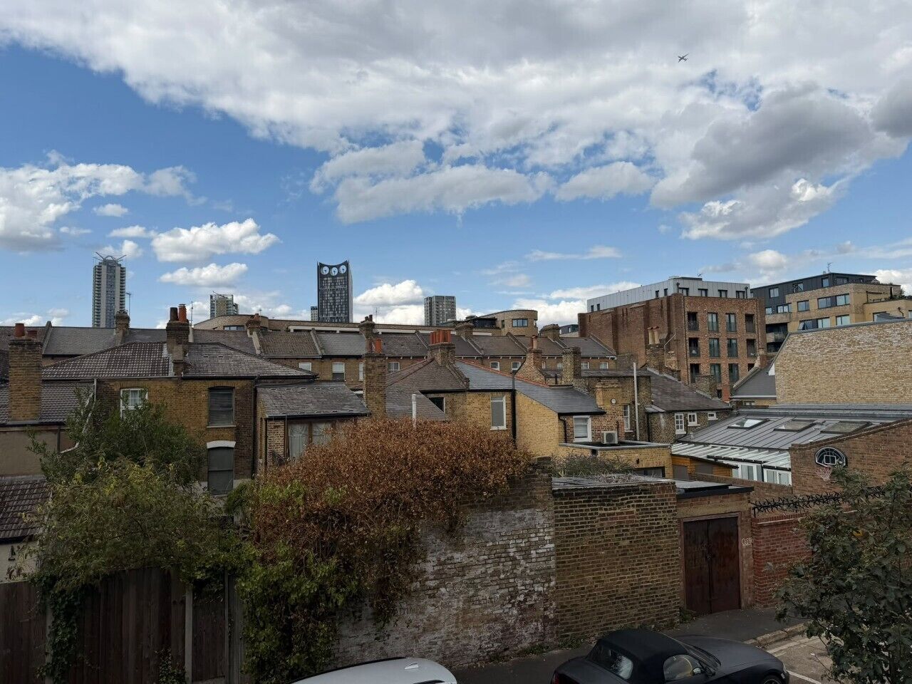 A residential area with a mix of older and newer buildings, some with visible chimneys and others with modern designs.