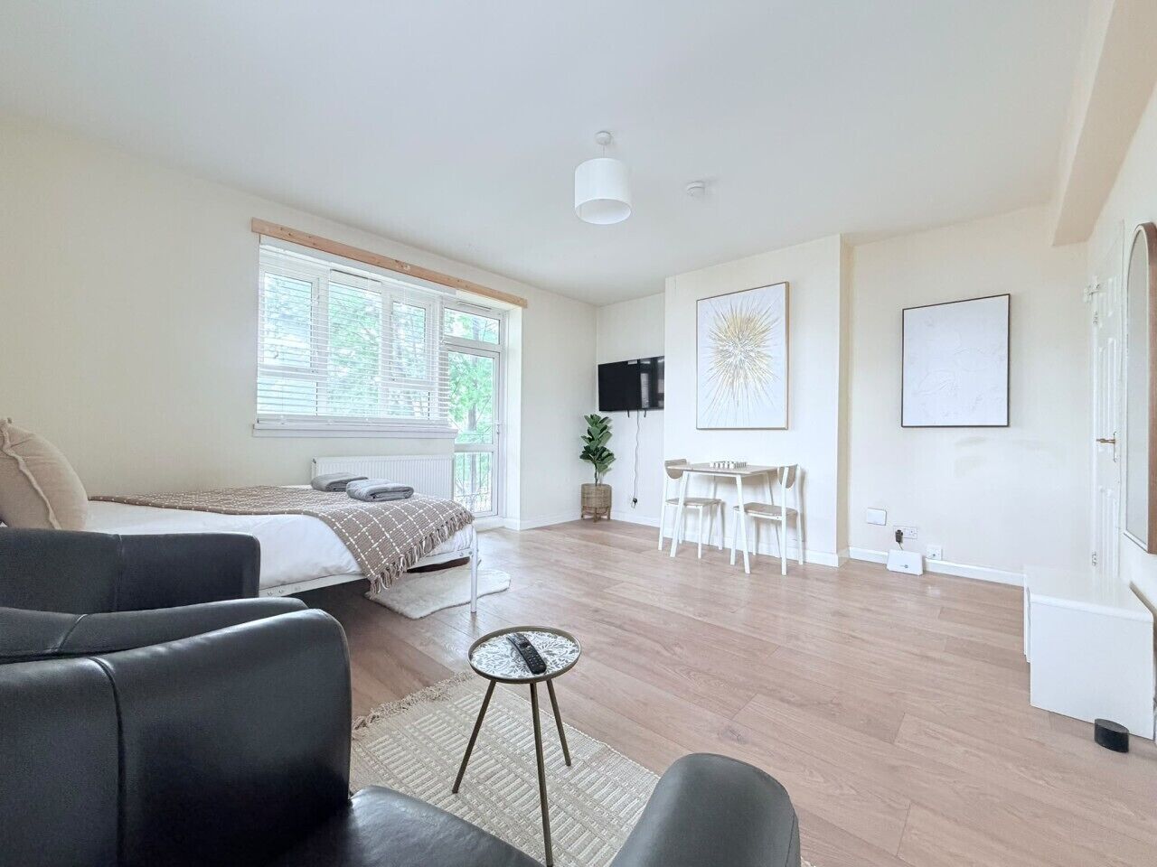 A modern living room with a sofa, a coffee table, and a dining area with chairs.