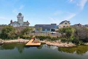 A residential area with houses, a dock, and a calm pond. - Cozy Cove - Hot Tub, Waterfront, Game Room Sleeps 6 (Ocean Shores)