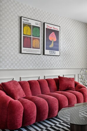 A modern living room with a red sofa, a coffee table, and two framed artworks on the wall. - Casa Positano® Designer 2BR/2BA in Irvine w/ Pool (Irvine)