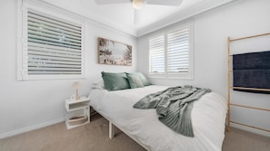 Ein Schlafzimmer mit Bett, Nachttisch und einem an der Wand befestigten Handtuchhalter.
