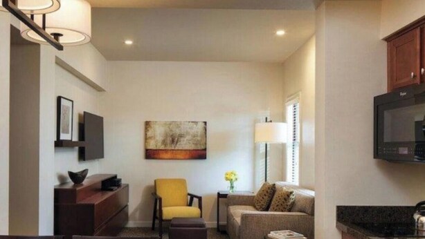Un salon moderne avec un canapé, un fauteuil et une table à manger.
