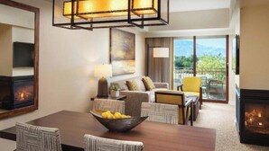 Une chambre d’hôtel comprenant un coin repas, un ensemble de canapés, une cheminée et une vue sur l’extérieur.