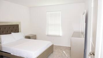 A bedroom with a bed, bedside table, and a wardrobe.