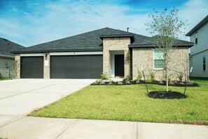 A residential house with a garage, a front lawn, and a small tree. - 5BR All One Level | Fenced Yard | Pet Friendly (Richmond)