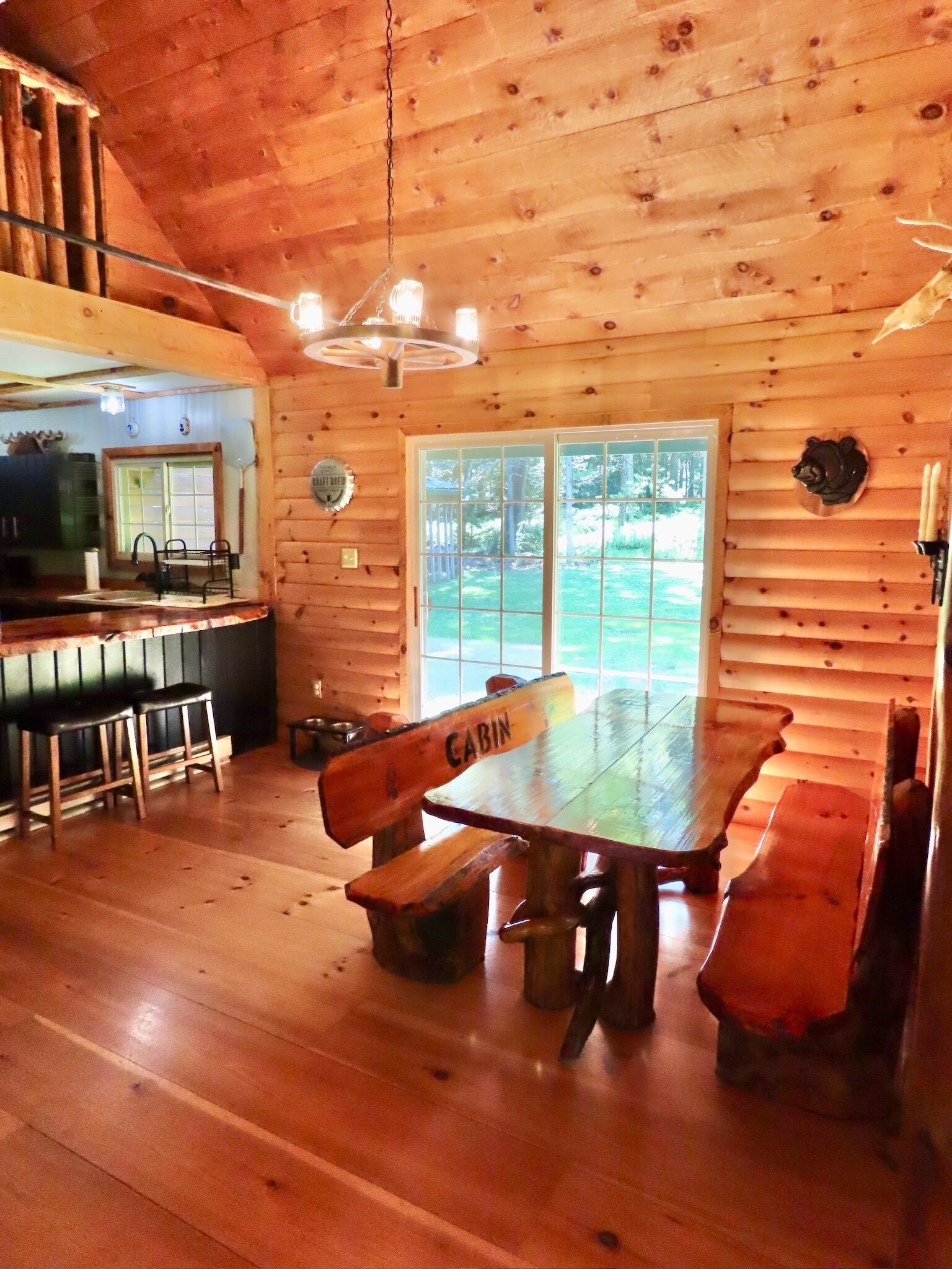 L’intérieur d’une cabane comprend une table à manger, des bancs, un coin cuisine et une grande fenêtre.