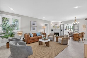 A modern living room with a sofa, chairs, a coffee table, and a fireplace. - Pink Palm Retreat - Pineapple Grove (Delray Beach)
