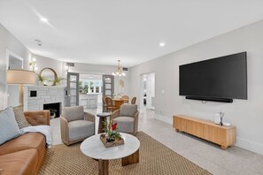 Ein modernes Wohnzimmer mit Kamin, Sitzecke und einem großen Flachbildfernseher.
