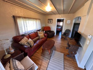 A cozy living room with a leather sofa, a wooden coffee table, and a fireplace.