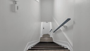 A staircase with wooden steps and a handrail, leading to a landing with a door.