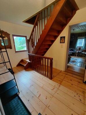 Eine Holztreppe mit Handlauf, die zu einer oberen Ebene führt.