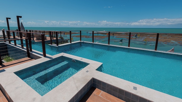 Una piscina con vistas a la playa y al océano.