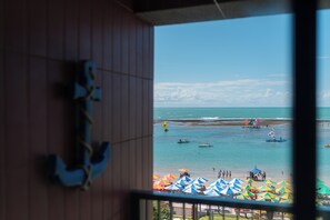 A view of the sea from a window with a wooden interior and a metal railing. - Smeralda del Mare by AFT (Ipojuca)