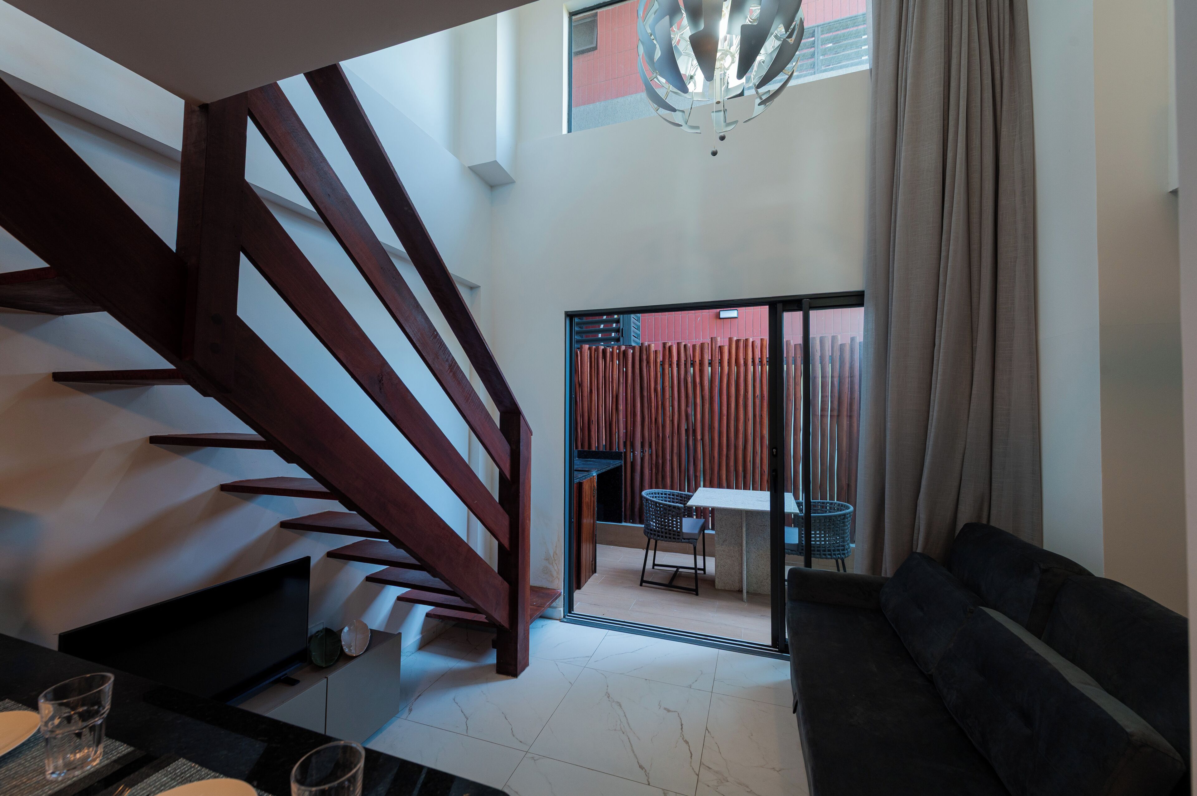 Un interior moderno con una escalera, un comedor y un sofá.