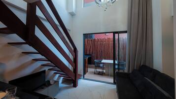 Un interior moderno con una escalera, un comedor y un sofá.