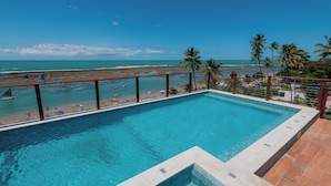 Una piscina con vista a la playa y al océano.