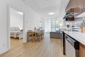 Une cuisine moderne équipée d’un lave-vaisselle, de meubles en bois et d’un coin repas avec une table et des chaises.