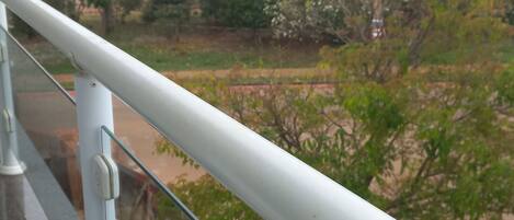 A balcony railing with a view of a residential area, including houses and trees.
