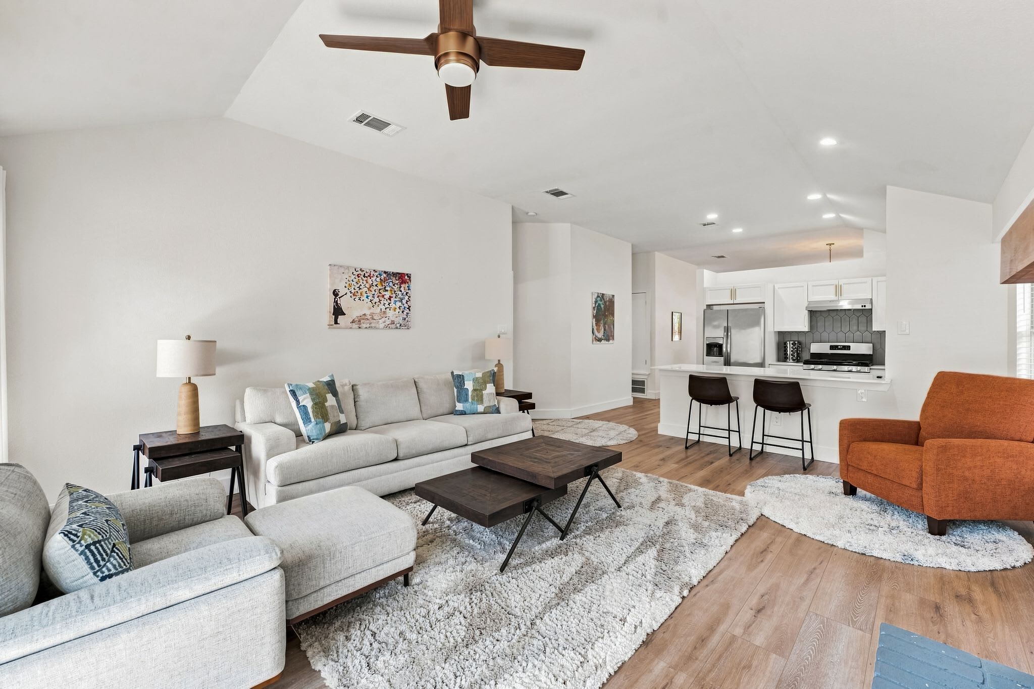 A modern living room with a sofa, coffee table, and a dining area with chairs.