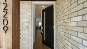 Un umbral que da a una habitación con piso de madera y una puerta negra.