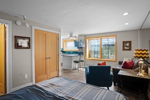 A modern interior with a bed, a desk, a chair, and a dining area. - Village Peak 9 Inn Ski-in/Ski-out Walk to Main St (Breckenridge)