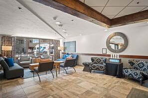 Un hall d’hôtel avec un espace salon, un miroir et une vue sur l’extérieur.