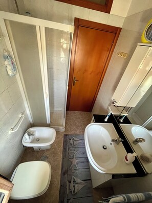 A bathroom with two sinks, a shower, and a toilet. - La Panchina on the Corso Vacation Rental (Grassano)