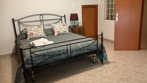 A bed with a metal frame, a patterned bedspread, and decorative pillows. - La Panchina on the Corso Vacation Rental (Grassano)