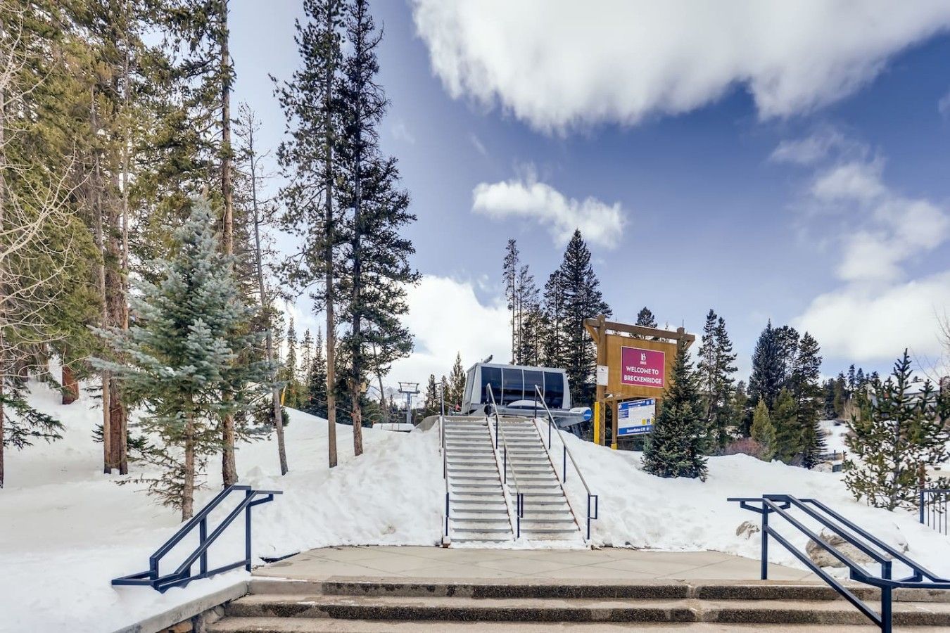 Un escalier recouvert de neige mène à un bâtiment sur lequel on peut lire l’inscription : « Bienvenue à Breckenridge. »