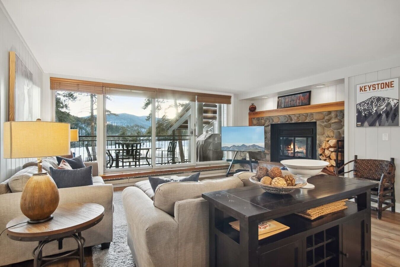 A modern living room with a fireplace, a television, and a view of the outdoors.