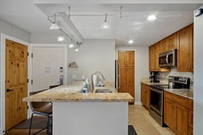 A modern kitchen with granite countertops, stainless steel appliances, and wooden cabinets. - 5 minutes from Keystone Resort with Hot Tub & Pool (Keystone)