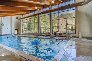 An indoor swimming pool with clear windows, lounge chairs, and a visible clock on the wall. - 5 minutes from Keystone Resort with Hot Tub & Pool (Keystone)