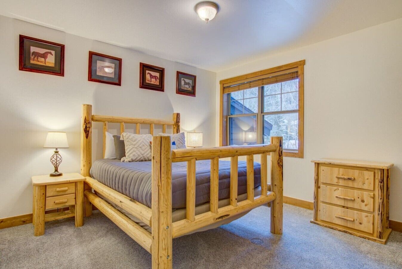 Ein Schlafzimmer mit einem Holzbett, Nachttischen, einer Kommode und gerahmten Bildern an der Wand.