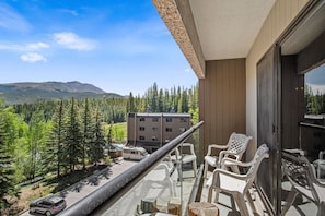 A balcony with a view of a mountain and forest, a parked RV, and a building in the background. - 1 Bedroom True Ski-in/out in Beaver Run Building 4 (Breckenridge)