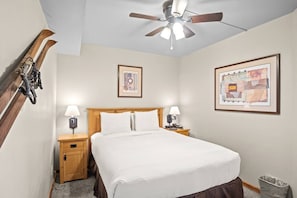 A hotel room with a bed, two bedside tables with lamps, a ceiling fan, and two framed artworks on the walls. - 1 Bedroom True Ski-in/out in Beaver Run Building 4 (Breckenridge)