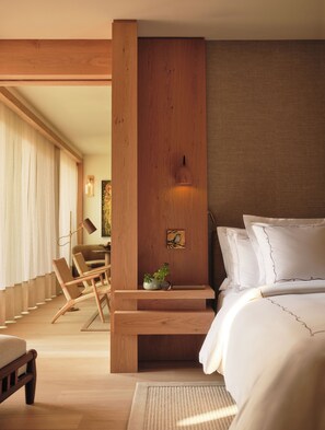 A bedroom with a bed, a wooden nightstand, a chair, and a desk. - Rosewood Calistoga (Calistoga)