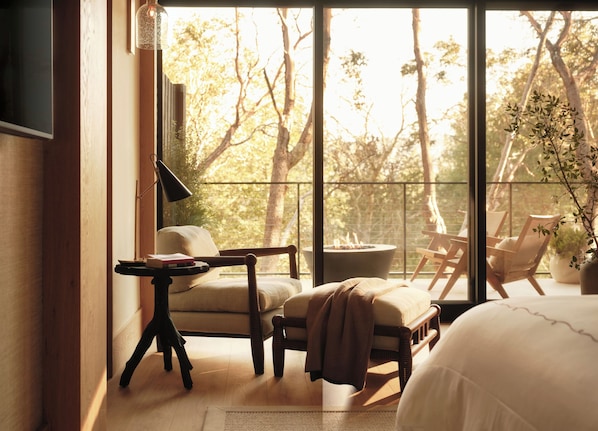A room with a large window, a bed, a chair, a table, and a plant. - Rosewood Calistoga (Calistoga)