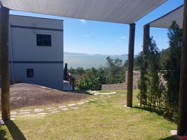 Un espacio al aire libre techado con vistas a un cuerpo de agua y montañas distantes.
