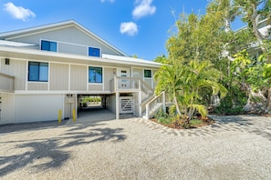 A two-story building with a covered driveway and a gated entrance. - Beachfront Gulf Cottage w/ Panoramic Gulf Views (Captiva)