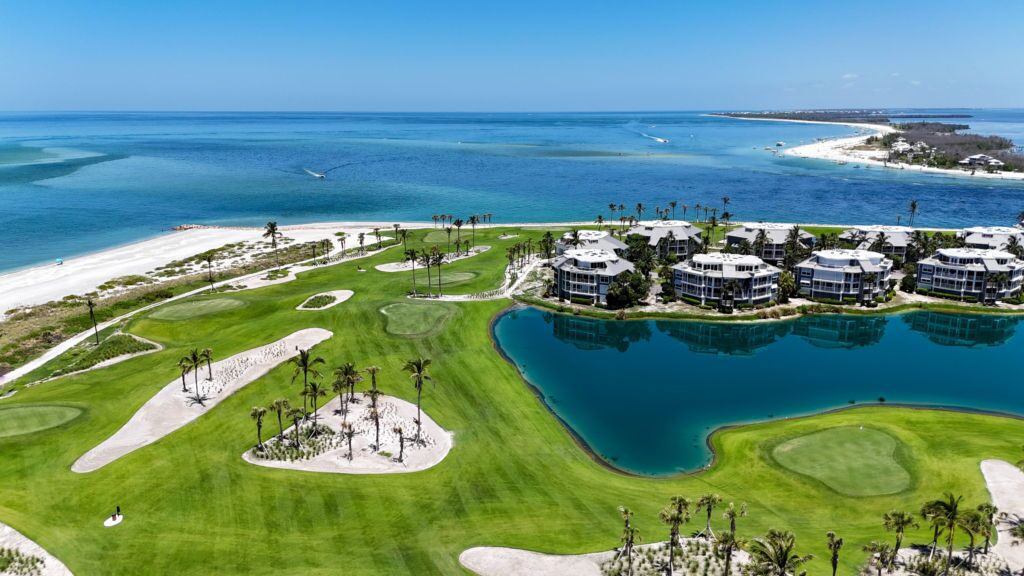 A golf course with bunkers, a water hazard, and a beach area.