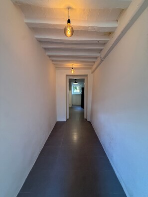 A hallway with a light fixture and a door at the end. - Stylish, high-end villa in the hills of Versilia with ocean views (Toscana)