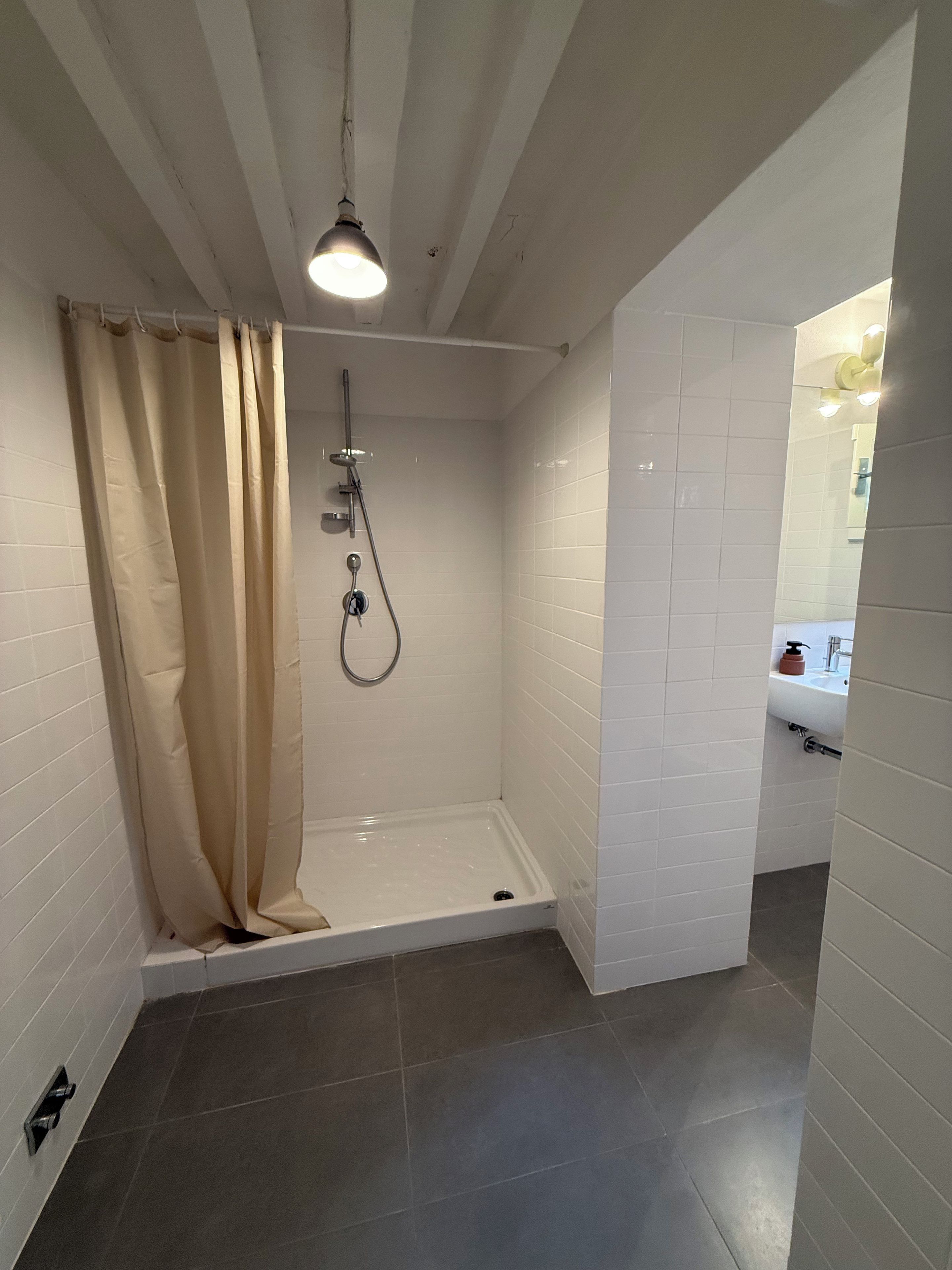 A bathroom with a shower, a toilet, and a sink.