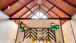 A room with a bed, a decorative headboard, and balloons. - All Natural Glamping (Copacabana)