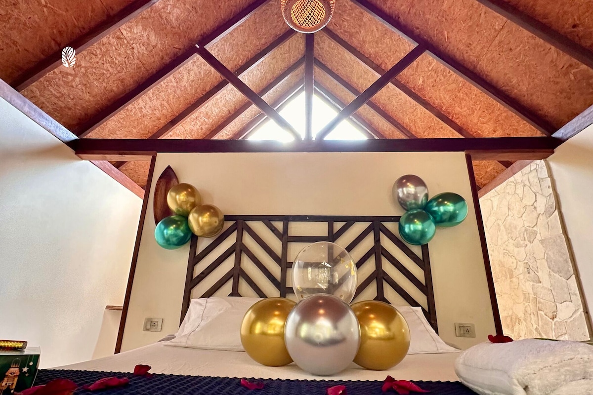 Een kamer met een bed, een decoratief hoofdeinde en ballonnen.