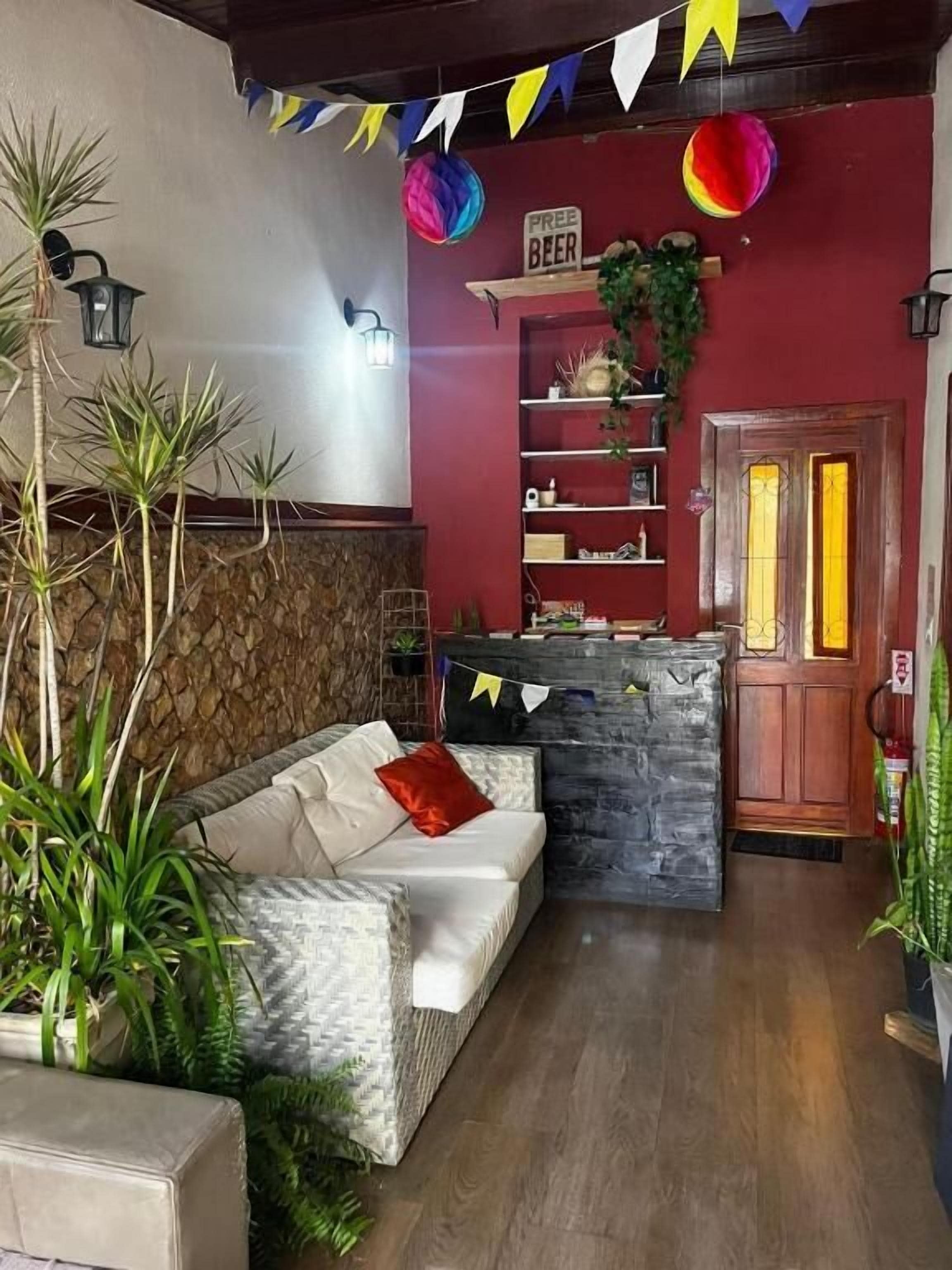 A cozy room with a sofa, a stone accent wall, a wooden door, and a shelf with various items.