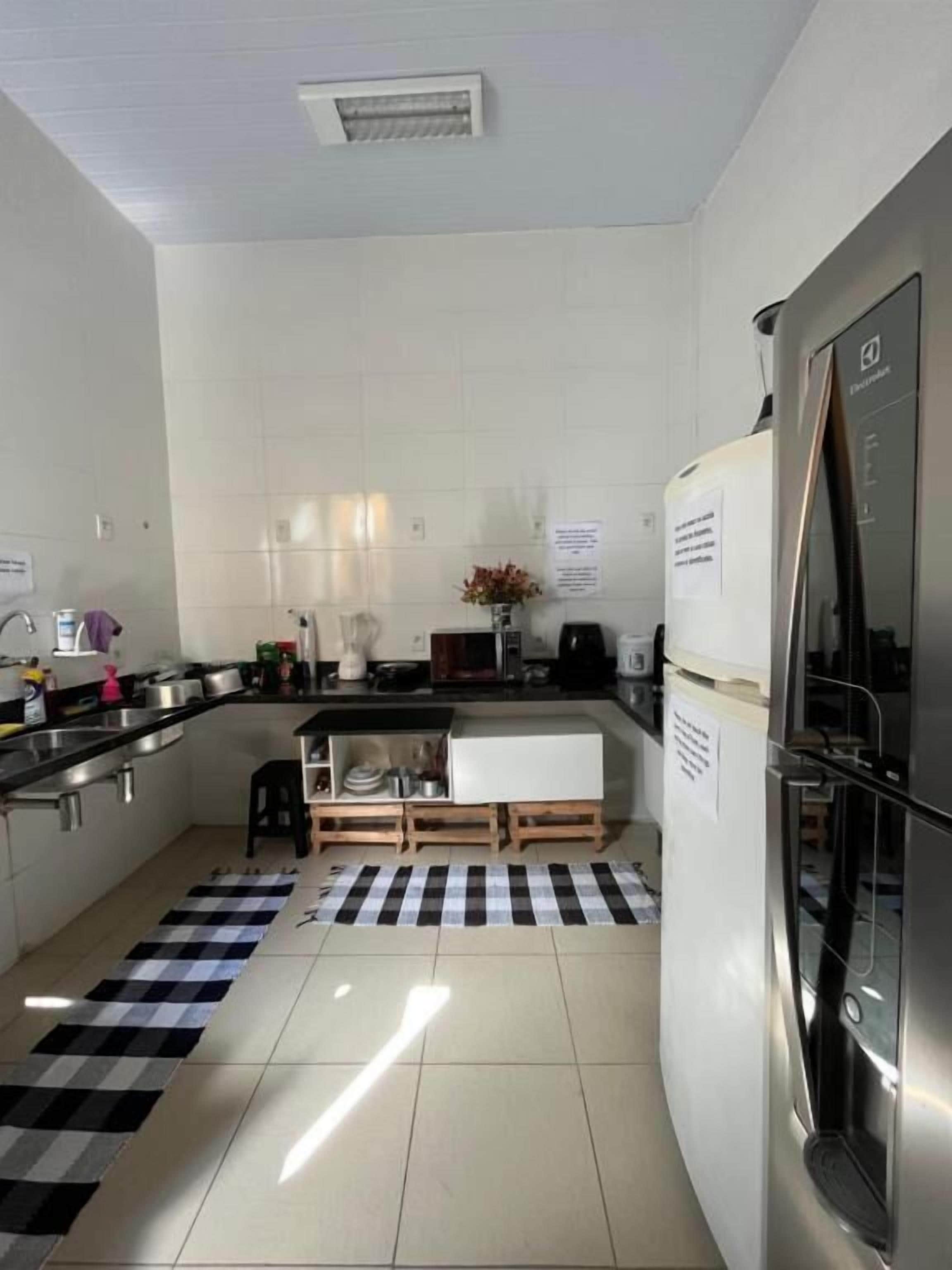 Cozinha compacta com geladeira, fogão e pia.
