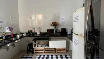 Cozinha compacta com geladeira, fogão e pia.