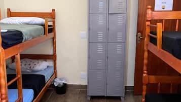 Quarto de dormitório com beliches, um guarda-roupa e uma porta com a etiqueta 'LIME'.