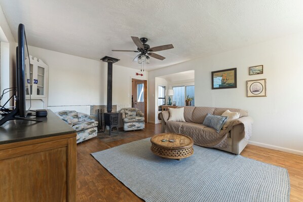 A living room with a sofa, armchair, coffee table, and a fireplace.